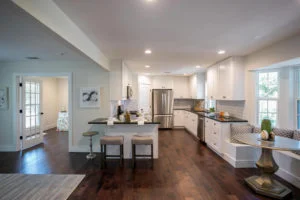 Modern kitchen featuring white shaker cabinets, dark wood flooring, and stainless steel appliances – custom design in Aransas Pass.