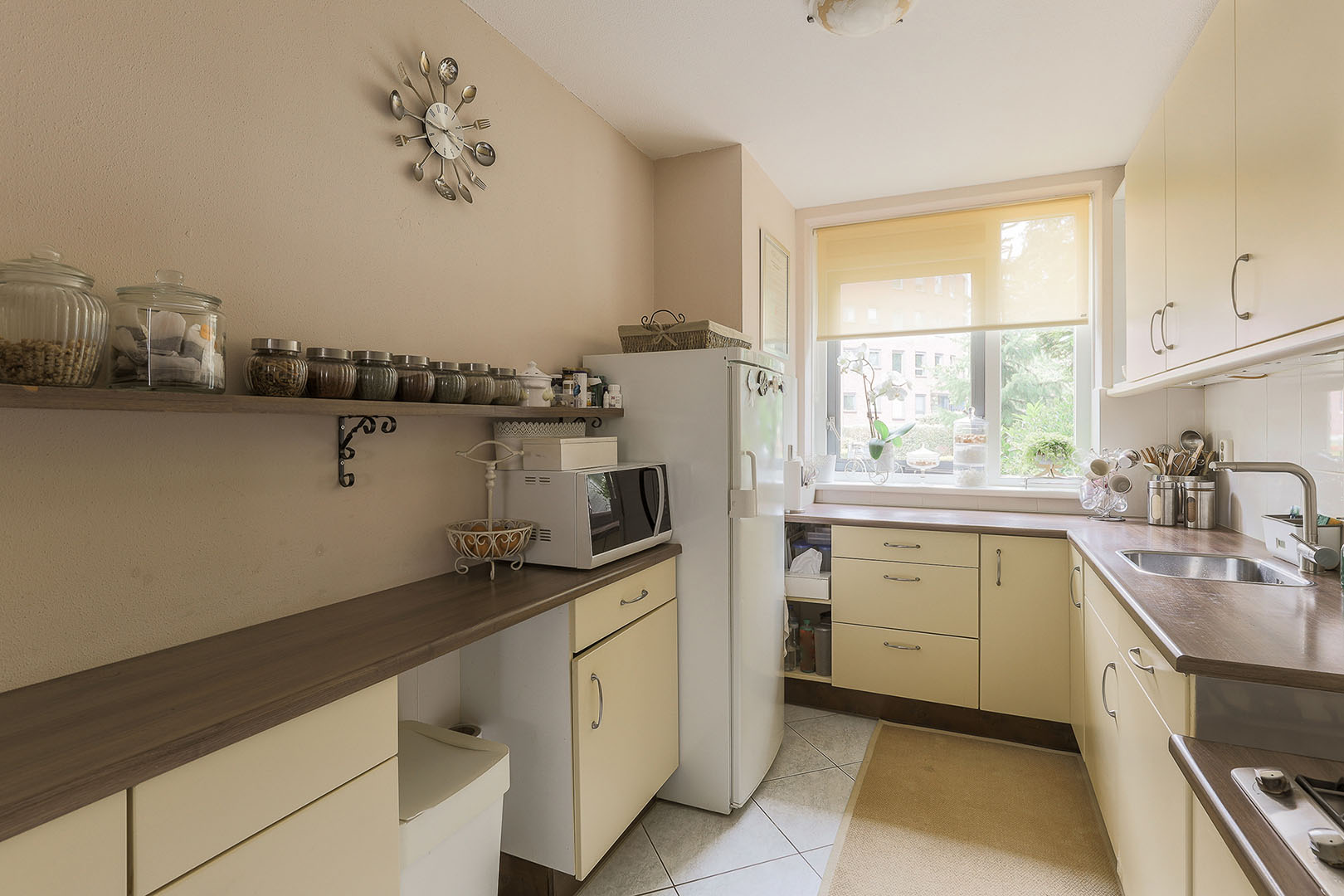 Spacious kitchen with cream cabinets, wooden countertops, and modern appliances – custom cabinetry for home renovations in Corpus Christi.